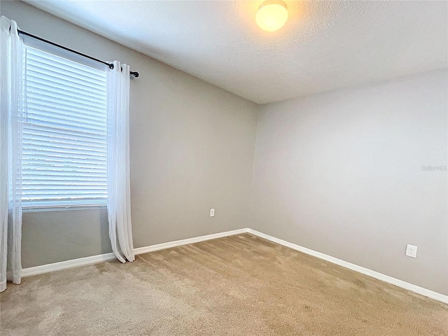 empty room with light carpet and a textured ceiling