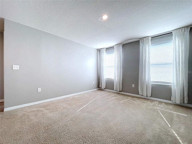 carpeted empty room with a textured ceiling