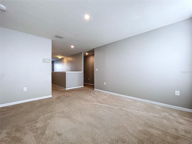 carpeted spare room featuring a textured ceiling