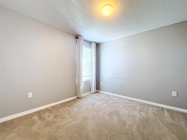 carpeted spare room featuring a textured ceiling