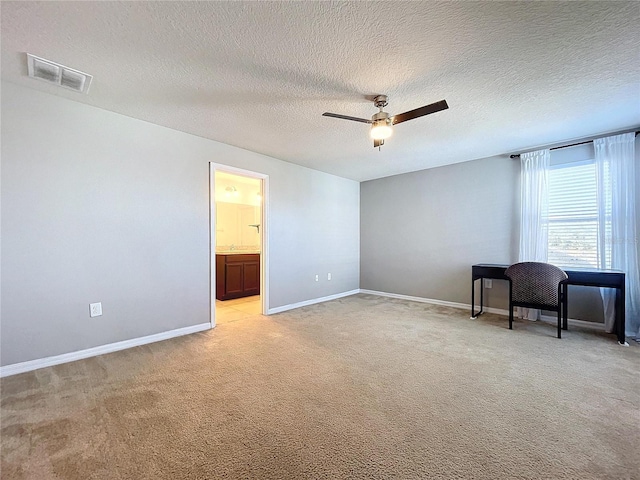 carpeted empty room with ceiling fan and a textured ceiling