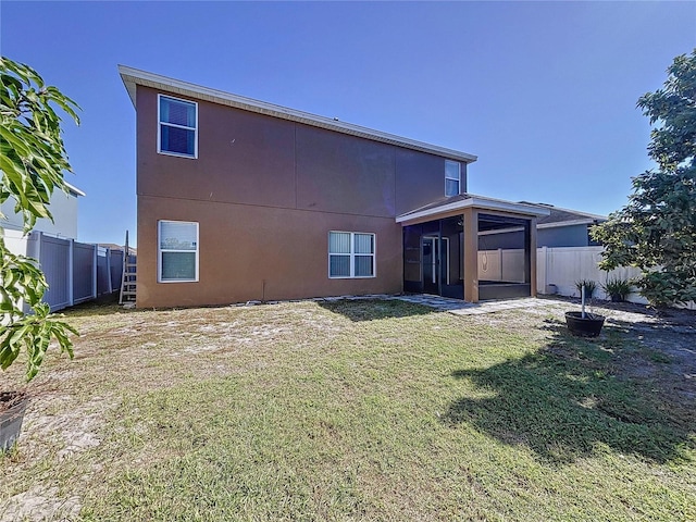 rear view of property with a sunroom and a yard