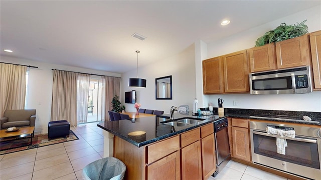 kitchen featuring hanging light fixtures, sink, light tile patterned floors, appliances with stainless steel finishes, and kitchen peninsula