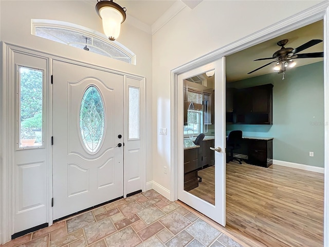 entrance foyer with ceiling fan and ornamental molding