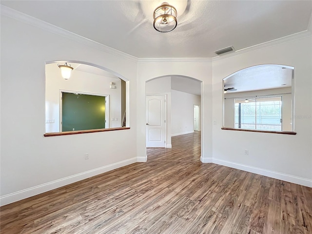 unfurnished room with ceiling fan, wood-type flooring, and ornamental molding