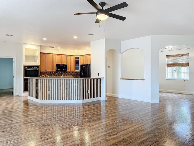 unfurnished living room featuring ceiling fan and dark wood-type flooring