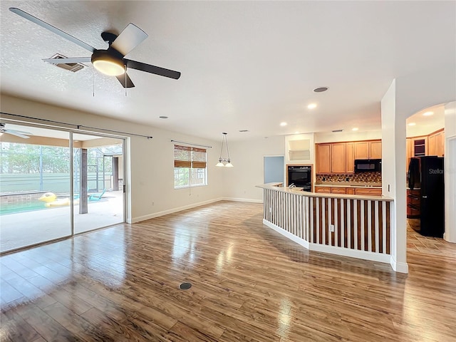 unfurnished living room featuring hardwood / wood-style floors and ceiling fan