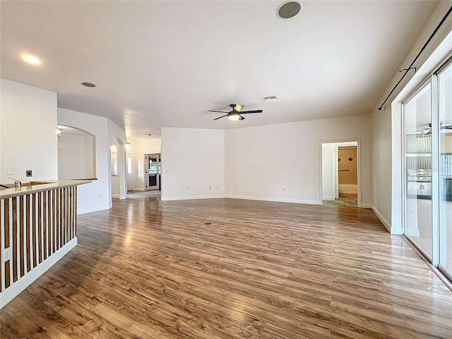 unfurnished living room with ceiling fan and hardwood / wood-style floors