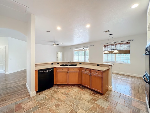 kitchen featuring dishwasher, sink, ceiling fan, a textured ceiling, and decorative light fixtures