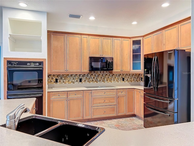 kitchen with black appliances, sink, and tasteful backsplash