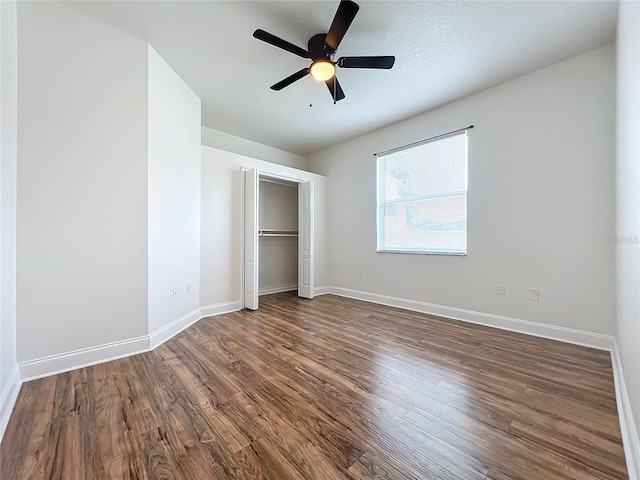 unfurnished bedroom with ceiling fan, dark hardwood / wood-style flooring, and a closet