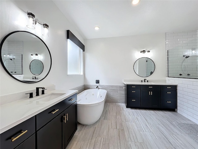 bathroom with plus walk in shower, vanity, and tile walls