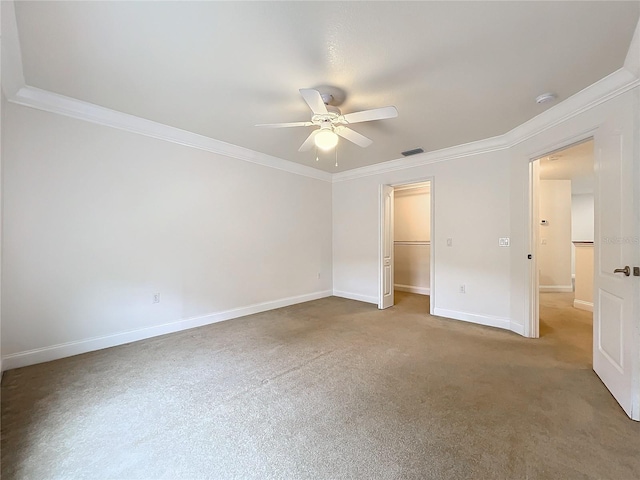 unfurnished bedroom with ceiling fan, a walk in closet, ornamental molding, and a closet