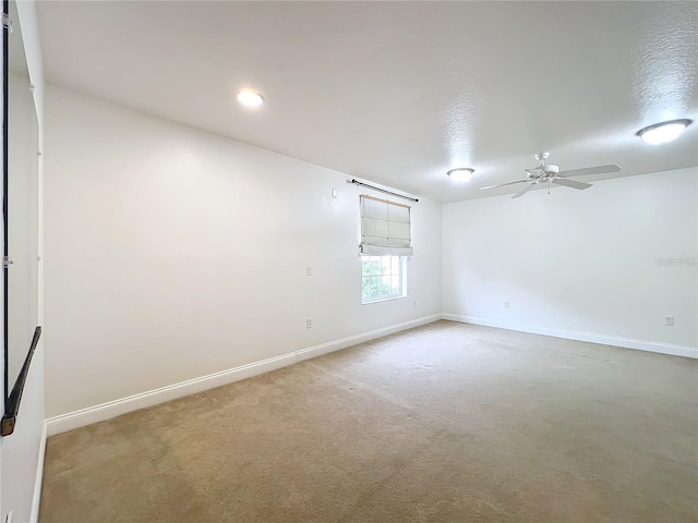 carpeted spare room with a textured ceiling and ceiling fan