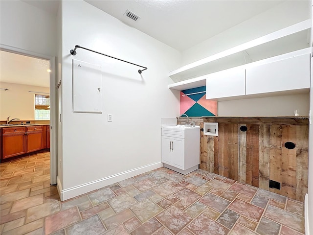 laundry room featuring cabinets, washer hookup, wooden walls, and sink