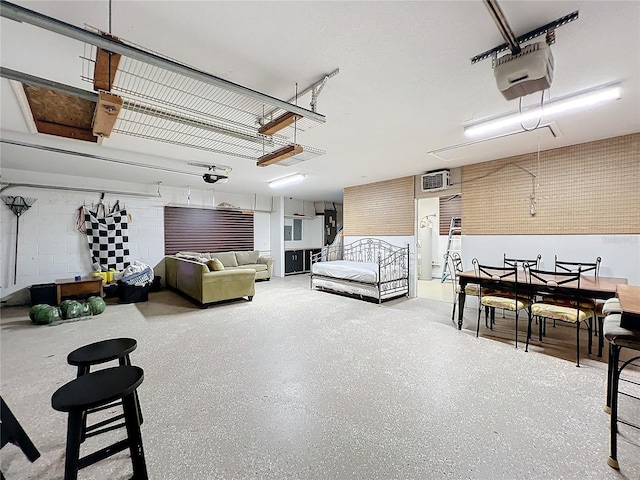 garage featuring a garage door opener and a wall mounted AC