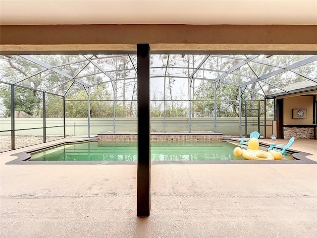 view of swimming pool featuring glass enclosure and a patio