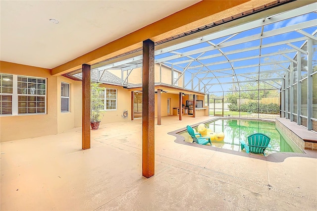 view of swimming pool featuring a hot tub, glass enclosure, and a patio area