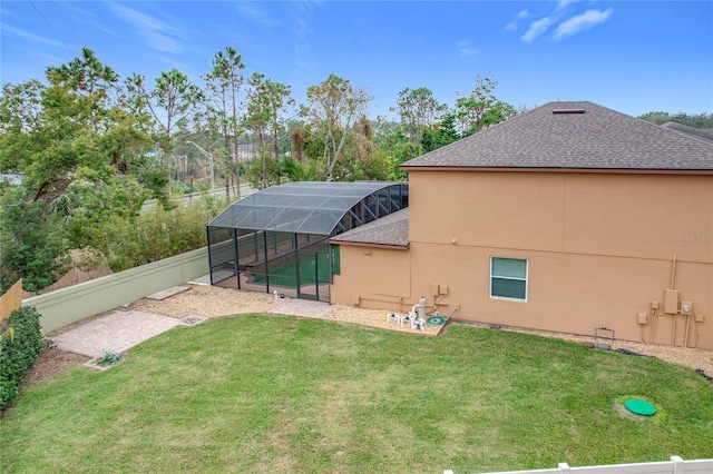 rear view of house with a lanai and a yard