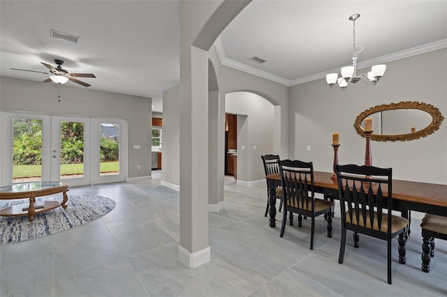 dining space with french doors, ceiling fan with notable chandelier, and crown molding