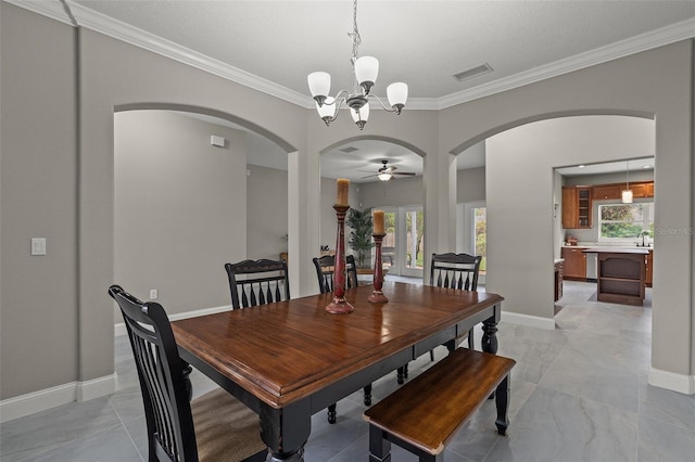 dining space with a wealth of natural light, crown molding, and ceiling fan with notable chandelier