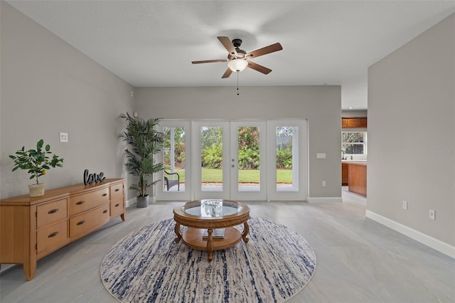 sitting room featuring ceiling fan and french doors