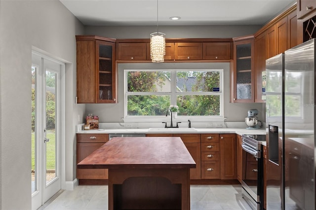 kitchen featuring sink, pendant lighting, plenty of natural light, and appliances with stainless steel finishes