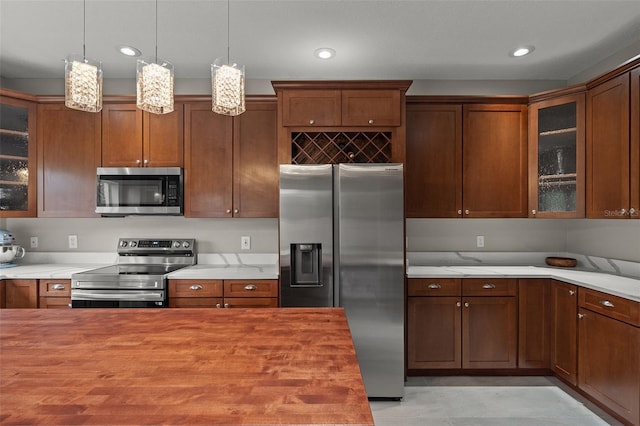 kitchen featuring pendant lighting, light stone countertops, and appliances with stainless steel finishes