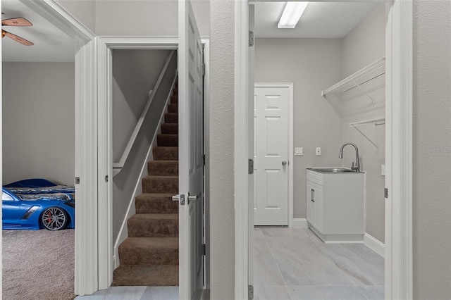 interior space with carpet flooring, ceiling fan, and sink