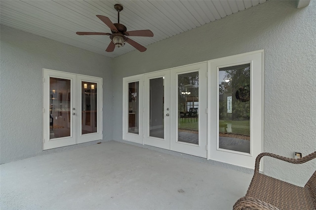 unfurnished sunroom featuring ceiling fan and french doors