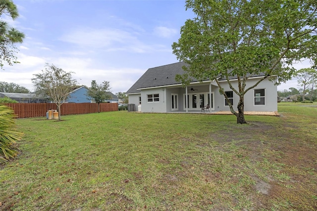 back of house with french doors, ceiling fan, cooling unit, and a lawn