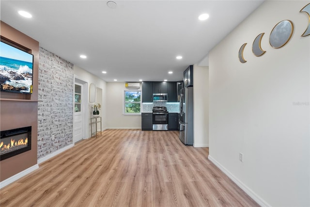 unfurnished living room featuring a large fireplace and light wood-type flooring