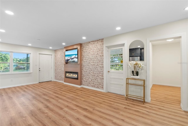 unfurnished living room with a fireplace and light hardwood / wood-style floors