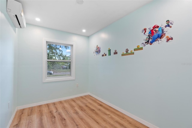 spare room with light hardwood / wood-style flooring and a wall mounted air conditioner