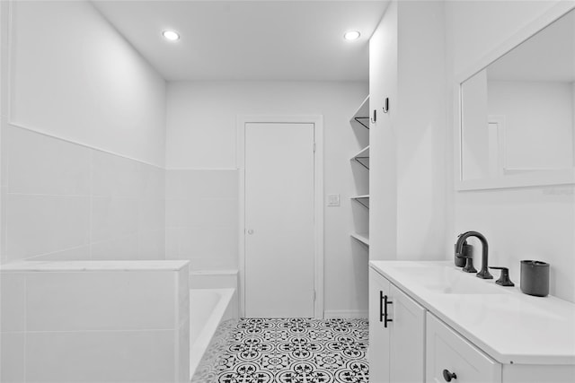 bathroom with a bath, vanity, and tile patterned floors