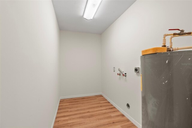 laundry area featuring water heater, washer hookup, and light wood-type flooring