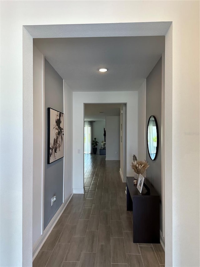 hall featuring baseboards and a wealth of natural light