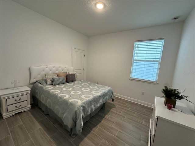 bedroom featuring wood tiled floor and baseboards