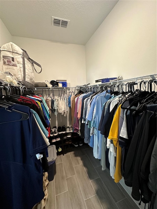 spacious closet featuring visible vents and wood finish floors