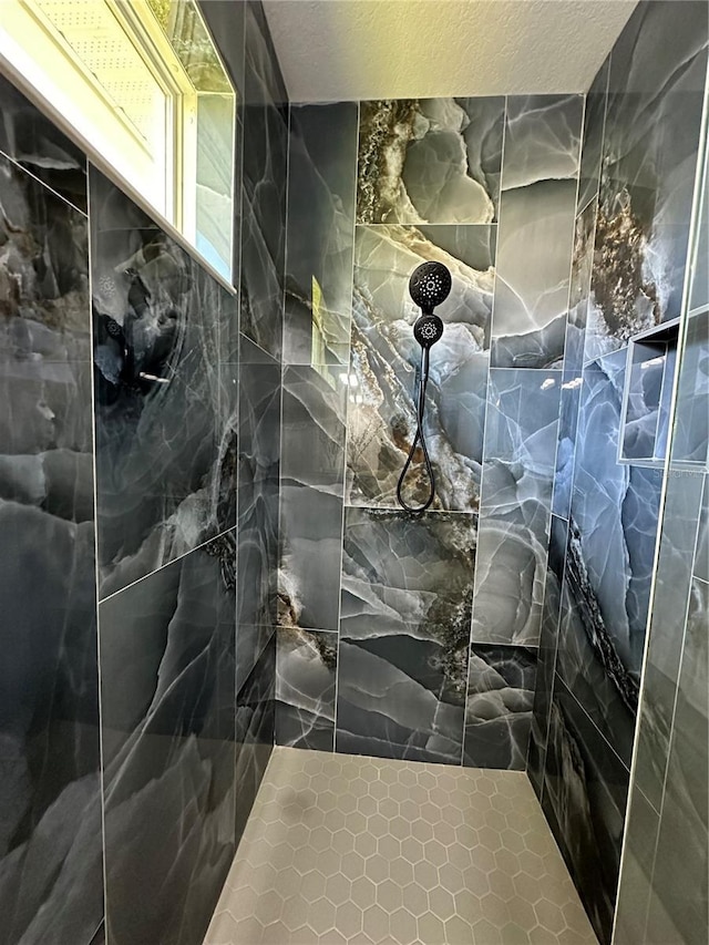 interior space featuring a tile shower and a textured ceiling