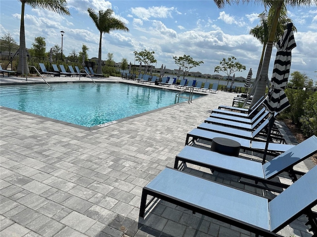 community pool with a patio and fence