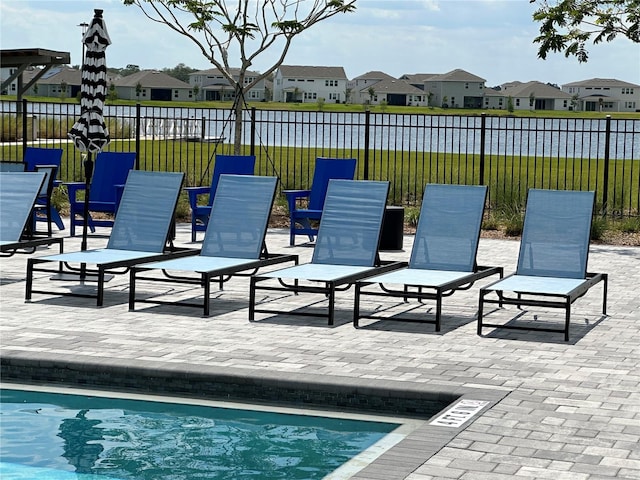 view of patio featuring a pool, fence, and a residential view