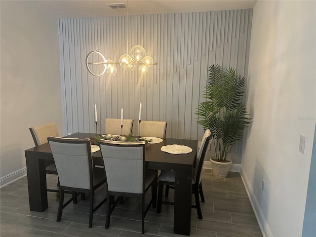 dining room featuring wood tiled floor, visible vents, and baseboards