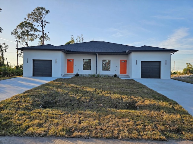 view of front of home with a front yard and a garage