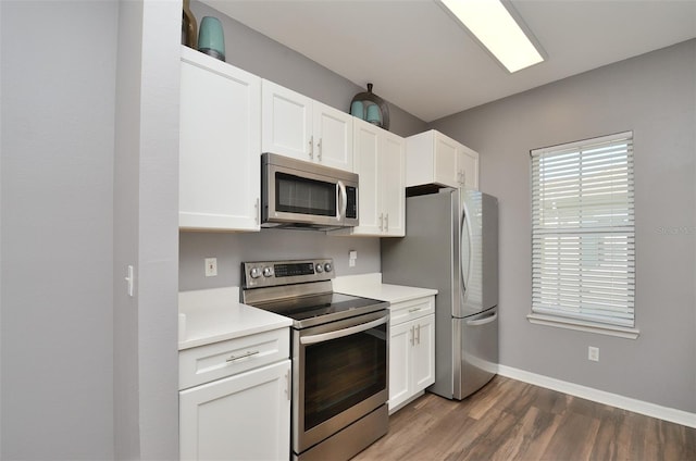 kitchen featuring appliances with stainless steel finishes, dark hardwood / wood-style floors, and white cabinetry