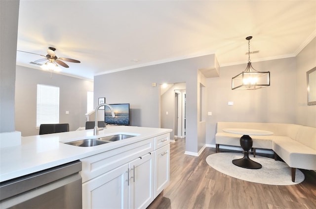 kitchen with dishwasher, sink, hanging light fixtures, white cabinets, and ornamental molding