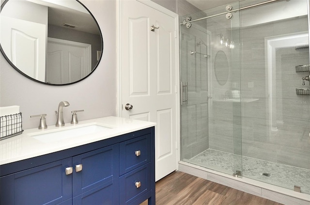 bathroom with vanity, an enclosed shower, and wood-type flooring