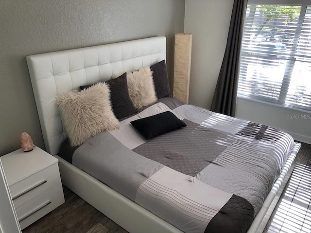 bedroom with dark hardwood / wood-style floors