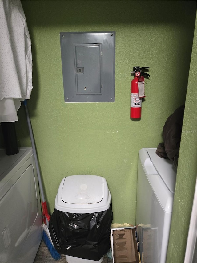 clothes washing area with washing machine and dryer and electric panel