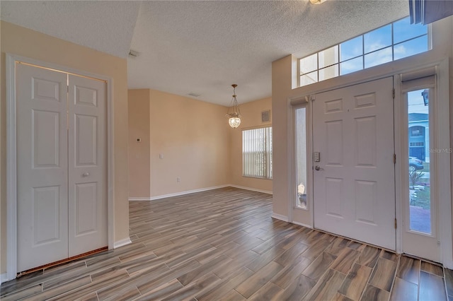 foyer featuring a chandelier and a textured ceiling